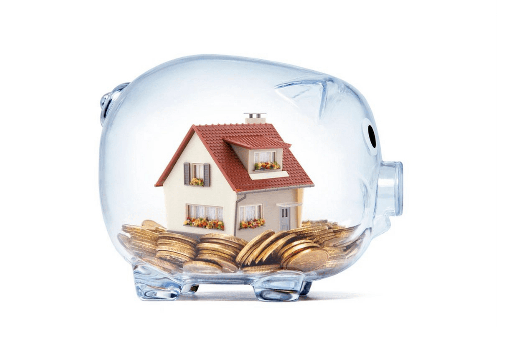 A glass piggy bank with coins in it and a house inside.